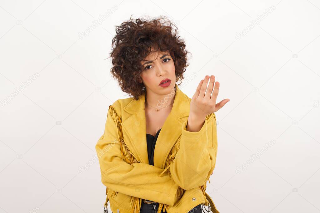 What the hell are you talking about, nonsense. Studio shot of frustrated  woman  gesturing with raised palm, frowning, being displeased and confused with dumb question over gray wall.