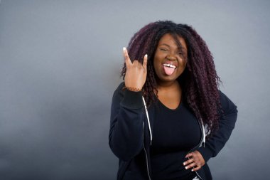 Sıradan giysiler içinde çılgın bir Afrikalı Amerikalı kadının portresi. Dili gösteriyor, jestler yapıyor. Konserde olmanın heyecanını dile getiriyor..