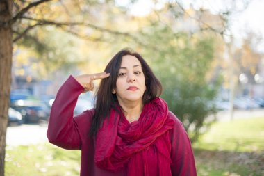 Parkta öldürücü bir jesti olan orta yaşlı güzel bir Arap kadın.  