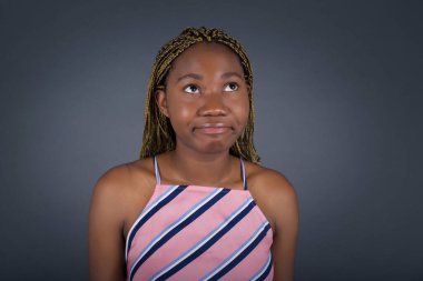 Hüzünlü, genç Afrikalı Amerikalı kadının dudaklarıyla baktığını, önemli bir şey hakkında üzüldüğünü, ellerini aşağıda tuttuğunu merak eden.