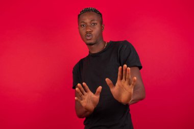 Tecrit edilmiş, korkmuş ve tiksinmiş genç adam iki elinle hareket etmeyi kes ve orada kal de. Panik konsepti.