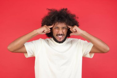 Kızıl duvarda başı ağrıyan afro saçlı genç adam. 