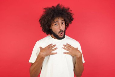 Kızıl duvarda afro saçlı kafası karışık genç adam. 