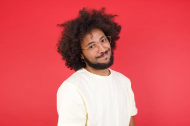 Kızıl duvarda saçları olan genç bir adam. 