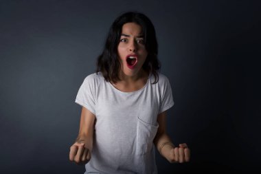 Sıradan kıyafetlerle, kollarını kaldırarak, yumruklarını sıkarak, neşe ve heyecanla golü haykırarak güçlü ve kararlı genç bir kadının portresi. Zafer, başarı ve başarı kavramı. 