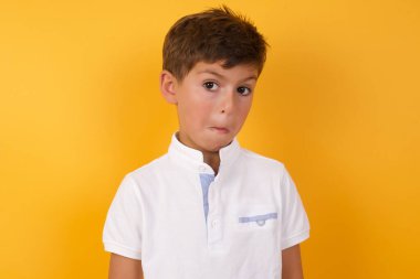Yakışıklı çocuğun sarı duvara karşı kafası karışık.  