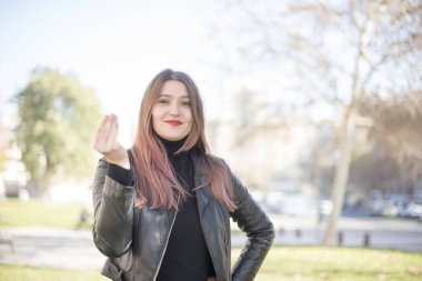 Parkta el kol hareketi yapan güzel bir kadın.