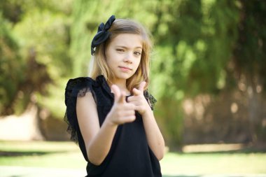 Hey sen, bang. Neşeli ve karizmatik güzel görünümlü duygusal kız kameraya mutlu ve küstah pozlar vererek göz kırpıyor ve parmaklarıyla kamerayı işaret ediyor. 