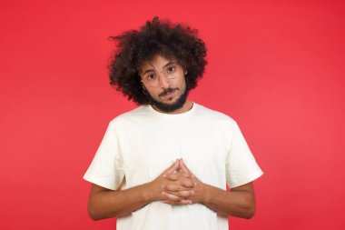 Kızıl duvarda saçları olan genç bir adam. 