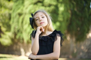 Yüz ifadeleri ve duygular. Düşünceli, genç ve güzel bir kız başının altında el ele tutuşuyor..