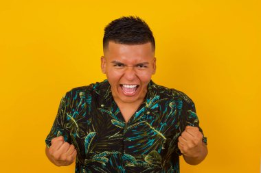 Yakışıklı İspanyol erkeğin portresi, kameraya heyecanla bakıyor, ellerini başının üstünde tutuyor, beklenmedik bir şey fark ediyor, duvarın üstünde izole edilmiş. Sevimli adam ani haberlere tepki verir..