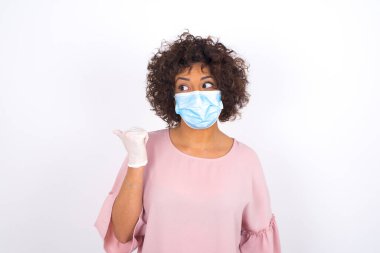 Yüz maskesi takan kadın ve günlük giysiler beyaz stüdyo arka planında izole edilmiş.