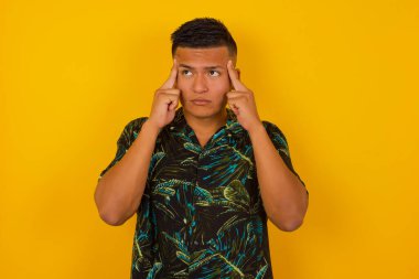 Hayalperest İspanyol bir erkek, düşünceli bir yüz ifadesi var, yüzünü çevirmiş, hoş bir şeyler düşünüyor, duvara karşı poz veriyor..