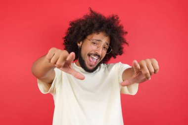 Kızıl duvarda kıvırcık saçlı genç adam.   