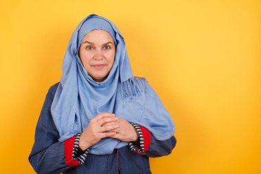 İş Konsepti - Orta yaşlı tesettürlü Müslüman kadın kendinden emin yüzüyle el ele tutuşuyor 