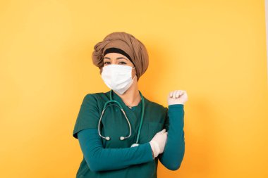 Yüzüne yakın, yeşil üniformalı, neşeli, genç, güzel Müslüman bir doktor resmi. İyi haberleri dinledikten sonra kameraya mutlu bir ifadeyle bakmak. Kendine güvenen kız..