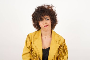 Düşüncelere dalan, kaşlarını kaldıran, dudaklarını kıvıran, şık kıyafetler giyen, metnin için fotokopi alanı olan gri duvara yaslanan düşünceli çekici bir kadın..