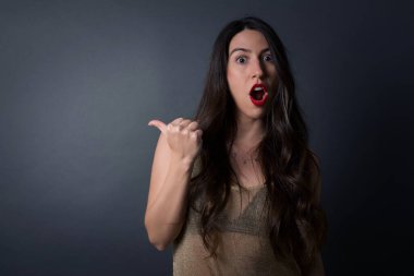 Gri arkaplanı işaret eden güzel kadın.  