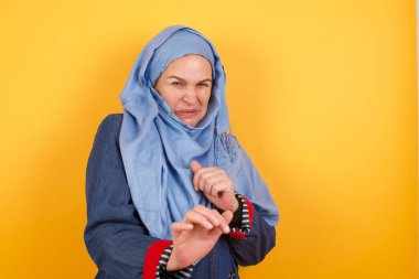 Ne kadar iğrenç! Hoşnutsuz orta yaşlı tesettürlü Müslüman kadın tatminsiz bir yüz ifadesi takınmıştır. Çünkü geçmişinde iğrenç ya da iğrenç bir şey görmüştür..