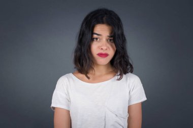 Üzgün, çaresiz, kederli, gözyaşları içinde, kederli bir kadının güzel yüzü. Acı ve depresyon çekiyor. Gri arka planda, üzgün bir yüz ifadesi ve duygu konseptiyle izole edilmiş..