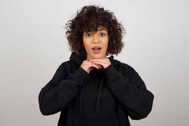 Gri arka planda elleri olan bir kadının çeneye dokunmasına çok şaşırdım.