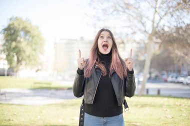 Genç ve güzel bir kadın parkı işaret ediyor. 