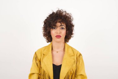 Süet ceketli güzel bir kadın kamera stüdyo çekimine bakıyor.