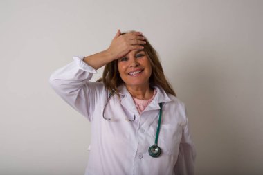 Tüh, ne yaptım ben? Olgun, beyaz, doktor kadın. Tıp üniforması giyiyor. Alnına korku ve pişmanlık ifadesi takınıyor..