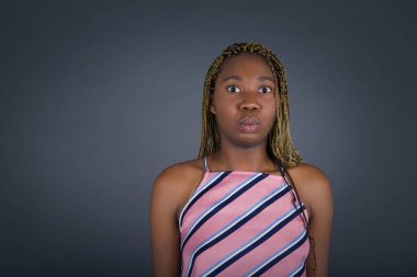 Şaşırdım. Güzel, Afro-Amerikan bir kadın. Gri arkaplan üzerinde izole.