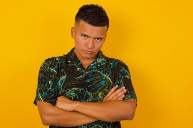 Parlak arka planda izole edilmiş öfkeli, yakışıklı İspanyol bir adamın resmi. Kameraya bak.