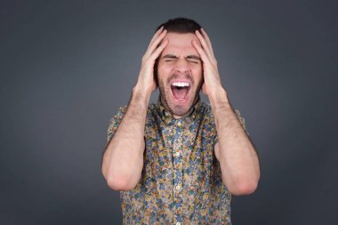 Şok olmuş beyaz bir adam şık giyinmiş kafasında el ele tutuşmuş ve umutsuzluk ve hüsran içinde çığlık atıyordu. Uçağa geç kalıyordu, gözleri dehşet içindeydi, ağzı açıktı.