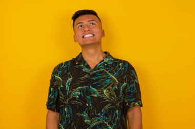 Esrarengiz bir gülümsemeyle yukarı bakan gizemli İspanyol erkek portresi. Yakışıklı, gülümseyen adam duvara bakıyor..