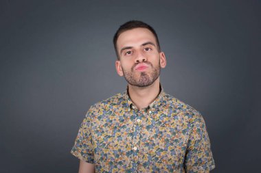 Hoş görünümlü, mavi gözlü, sarı saçlı, dudaklarını öpecek gibi tutan, mutlu bir ifadesi olan, suratını asık suratlı genç bir erkek. Kapalı yerde dikiliyorum. Güzellik konsepti.