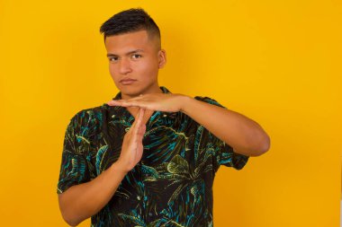 Genç ve güzel İspanyol bir adam yorgun ve sıkkın, bir mola jesti yapıyor, iş stresi, zaman kavramı yüzünden durmak zorunda. Duvara yaslanarak.