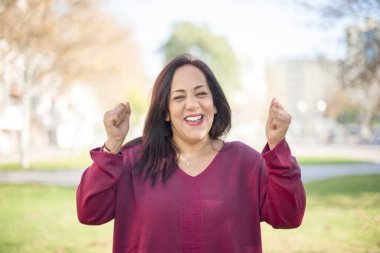 Parkta yumrukları olan heyecanlı orta yaşlı bir Arap kadın.  