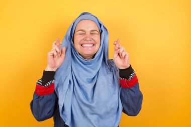 Kazanmak zorundayım. Keyifli orta yaşlı tesettürlü Müslüman kadın dişlerini sıkar, parmaklarını çapraz yapar, arzulanan bir dilekte bulunur, gündelik kıyafetler giyer, iyi haberleri bekler, duvarın üzerinde durur.