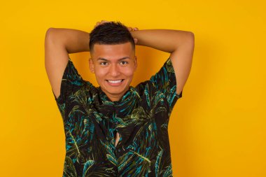 Yakışıklı İspanyol erkeğin portresi kameraya heyecanla bakıyor, ellerini başının üstünde tutuyor beklenmedik bir şey fark ediyor, duvarda izole edilmiş. Genç adam ani haberlere tepki veriyor..