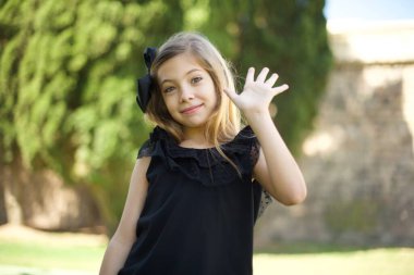 Siyah elbiseli, cana yakın, cana yakın bir kızın portresi bir elini kaldırıp selam veriyor, merhaba diyor ve tasasız bir şekilde gülümsüyor. Veda ediyor ya da hoş geldin işareti yapıyor..