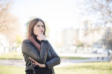 Parkta düşünen genç ve güzel bir kadın