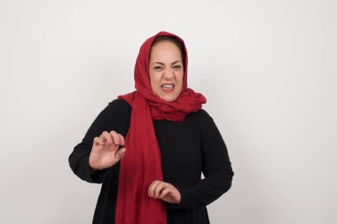 Ne kadar iğrenç! Olgun Müslüman kadın memnun değil, diyor ve tatminsiz bir yüz ifadesi var çünkü arka planda iğrenç ya da tiksindirici bir şey görüyor..