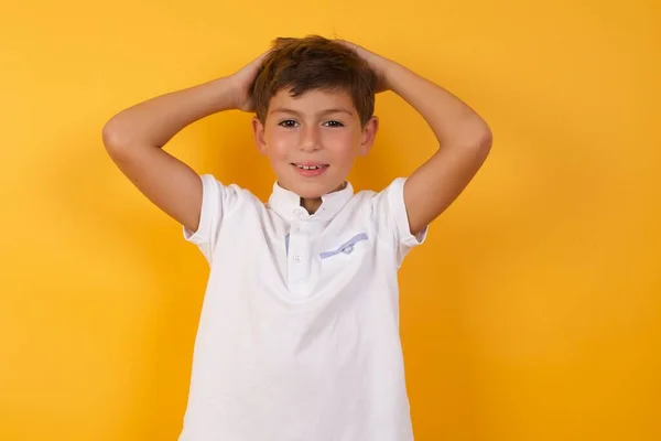 Mignon Garçon Avec Les Mains Derrière Tête Contre Mur Jaune — Photo