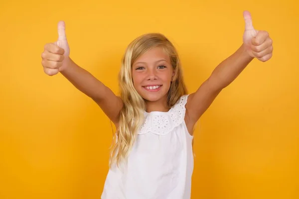 Menina Bonito Vestido Rosa Contra Fundo Estúdio Amarelo Com Polegares — Fotografia de Stock