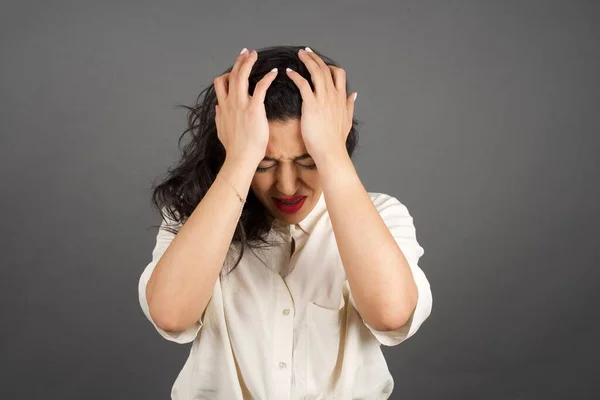 Mooie Brunette Vrouw Gekleed Terloops Met Hoofdpijn Tegen Grijze Achtergrond — Stockfoto