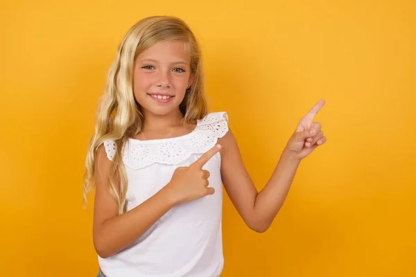 cute  girl pointing   on yellow background