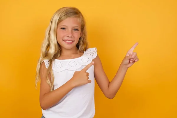 Cute Young Blonde Little Girl Yellow Studio Background Pointing — Stock Photo, Image