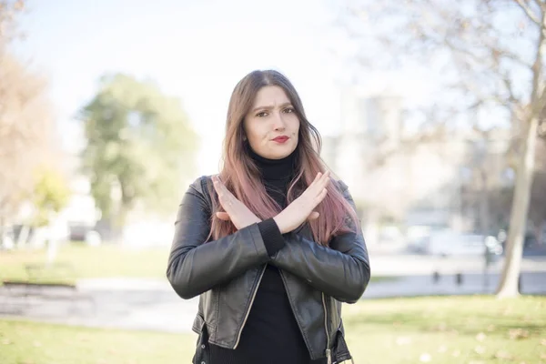 young beautiful woman   with stop gesture  in the park