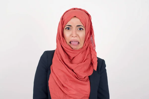 消极的人类表情和态度 怒气冲冲的穆斯林美女身穿黑色西装 头巾有着令人恶心的表情 因为她看到一些不吸引人的东西 皱着眉头 被白色的背景隔离了 厌恶和不喜欢 — 图库照片