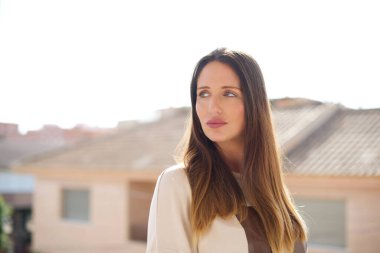 Genç ve güzel bir kadın caddeye bakıyor. 