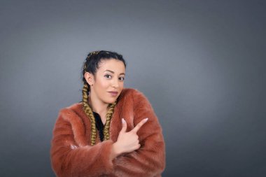 Kamerada poz veren güzel esmer bir kadın. Alengirli bir bakışla ve el kol hareketleriyle. Hareket kavramı.