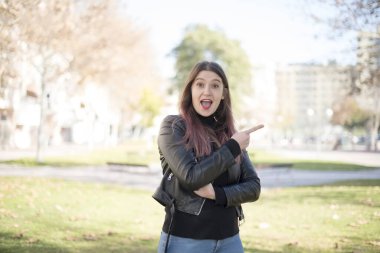 Genç ve güzel bir kadın parkı işaret ediyor. 